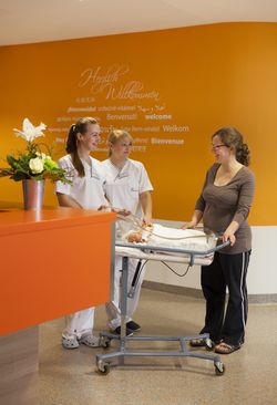 Pflegerinnen und Mutter vor Säugling